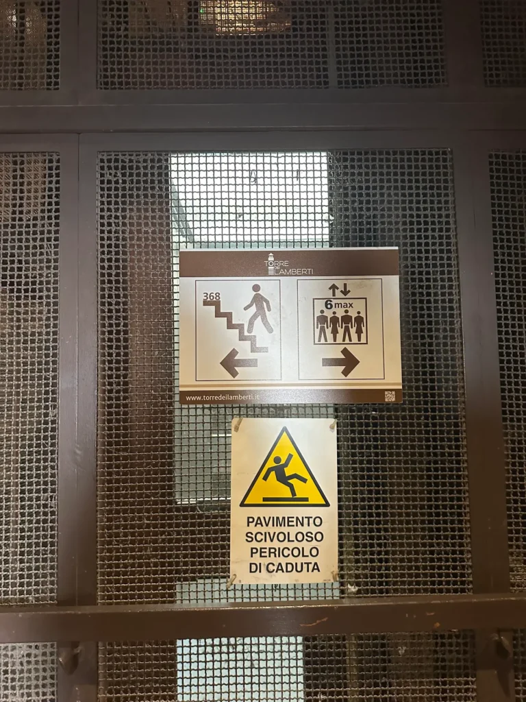 Mesh safety barrier inside Torre dei Lamberti observation deck that makes photography difficult.