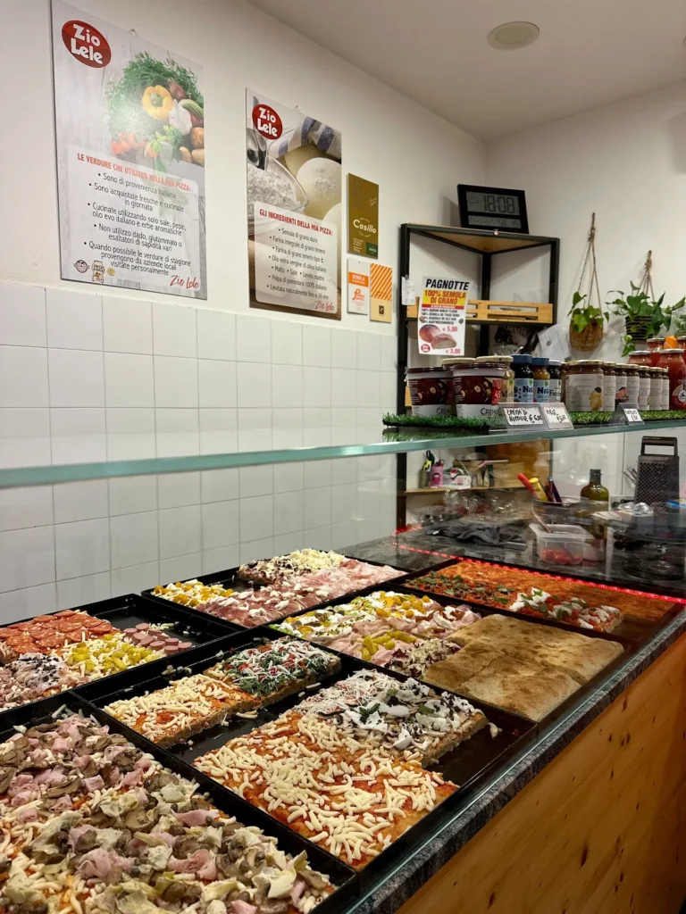 Zio Lele Verona pizza by the slice display with assorted toppings – what to eat in Verona local pizzeria