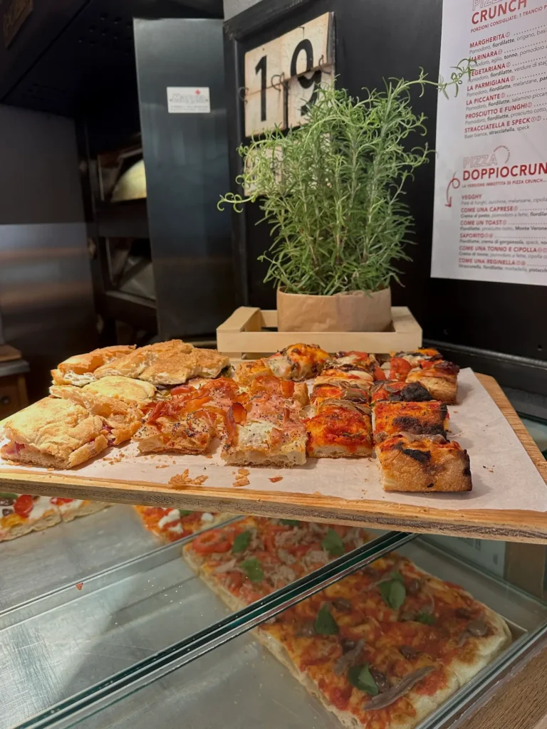 Best tours in Verona food stop featuring pizza slices at local bakery Cruncheria Verona
Caption:
