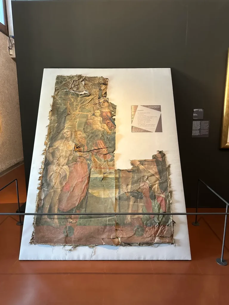 Fragmented medieval fresco at Castelvecchio Museum in Verona, featuring faded religious figures on a damaged and partially restored canvas display
