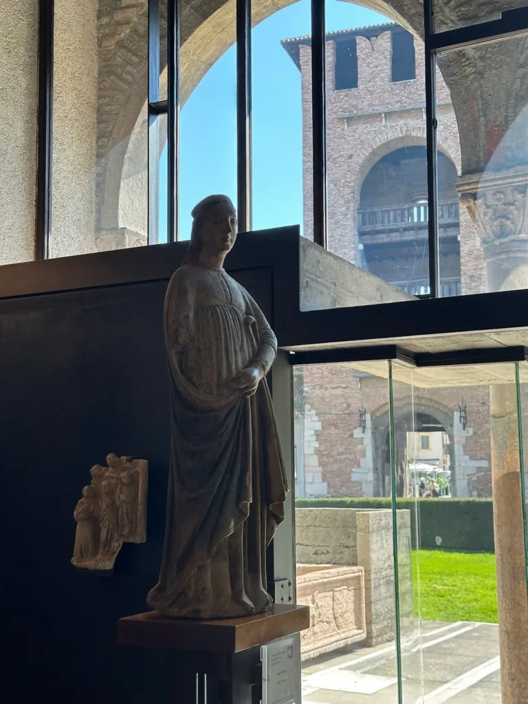 Castelvecchio Museum Verona sculpture of Saint Libera displayed near a window with views of the castle courtyard.