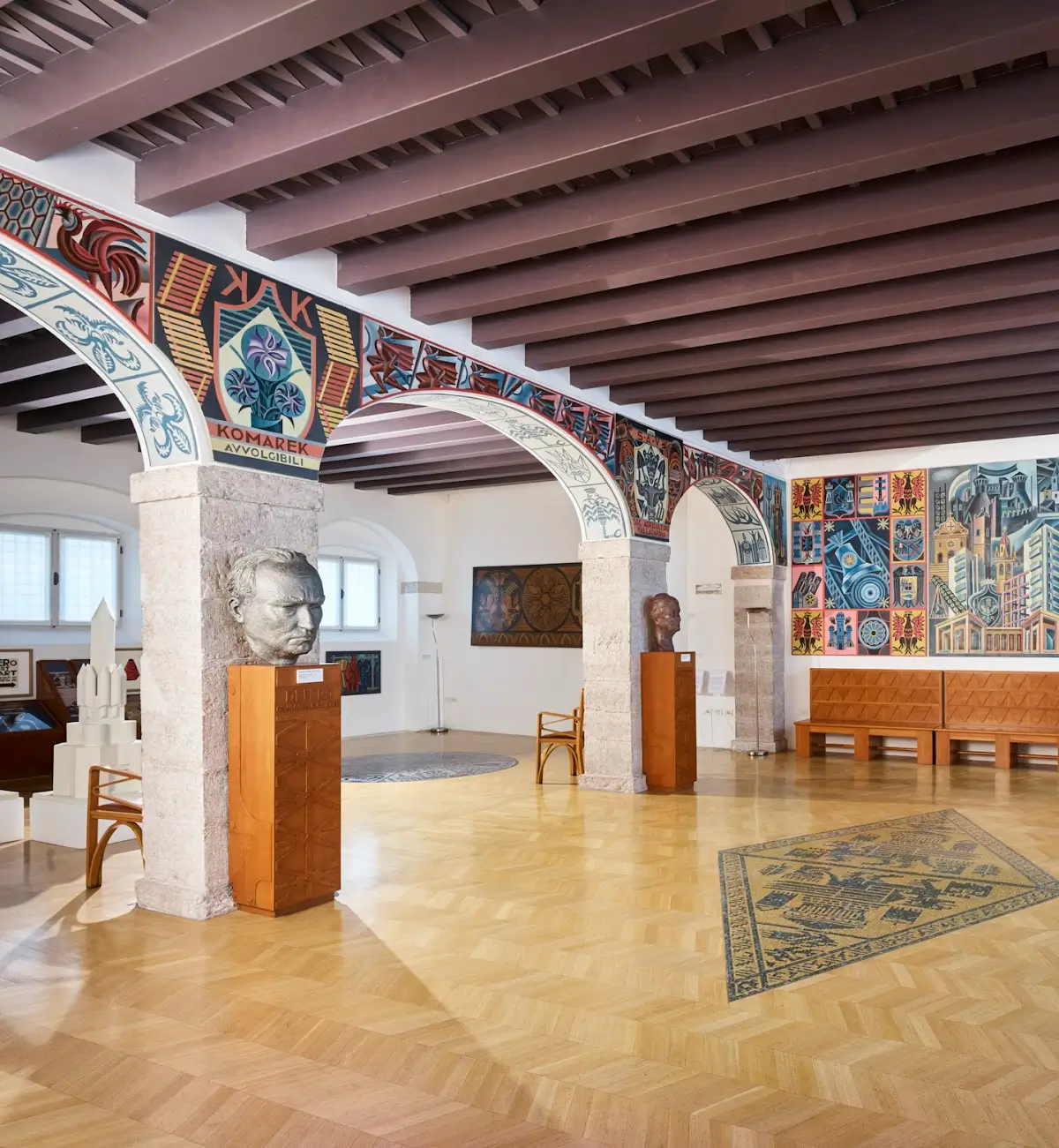 Interior of the Casa d'Arte Futurista Depero in Rovereto, showcasing colorful Futurist murals, patterned arches, and wooden sculptures.