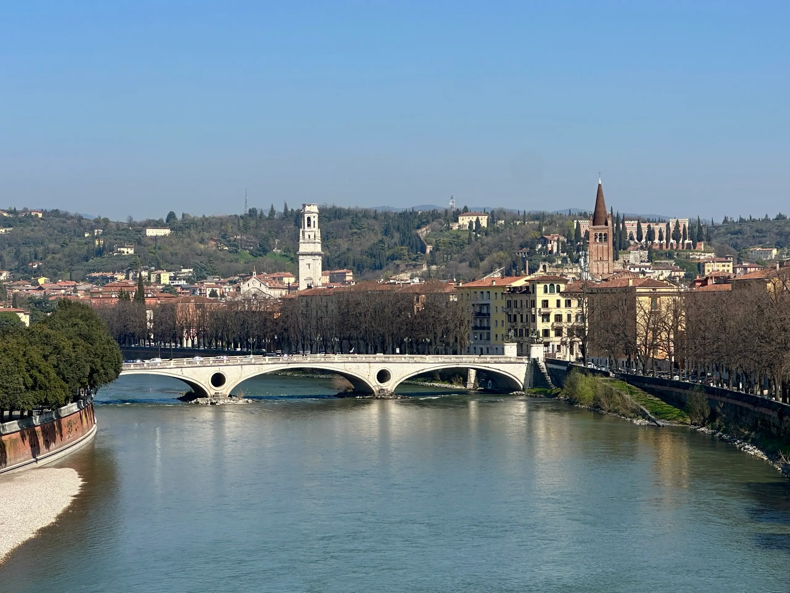 View of the Adige River and Verona skyline from Ponte Pietra, a scenic stop and one of the best free things to do in Verona on foot.
