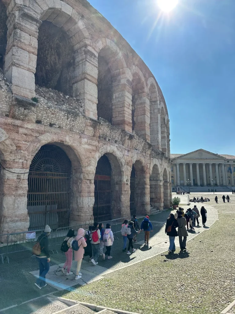 Best tours in Verona walking tour group outside Arena di Verona with historic arches and Piazza Bra